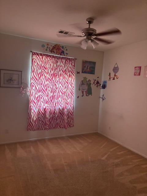 unfurnished room featuring carpet flooring and ceiling fan