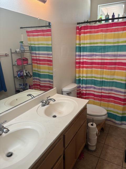 bathroom featuring tile patterned flooring, vanity, toilet, and a shower with curtain