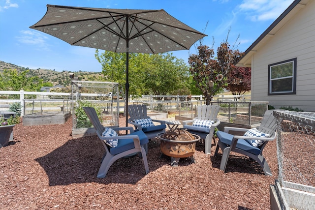 view of patio / terrace featuring an outdoor fire pit and a garden
