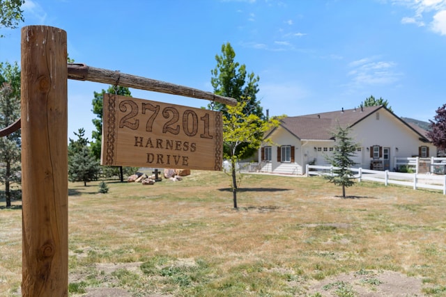 community sign with an attached garage and driveway