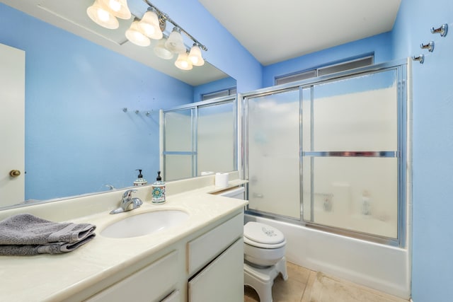 full bathroom featuring shower / bath combination with glass door, tile patterned flooring, vanity, and toilet