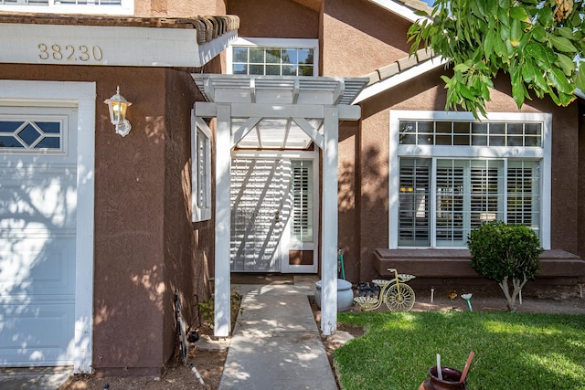 view of exterior entry featuring a pergola