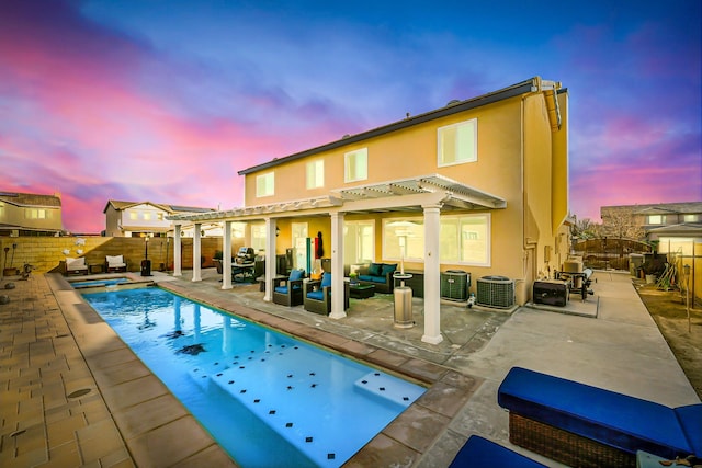 back of house with stucco siding, a fenced backyard, an outdoor hangout area, and a pergola