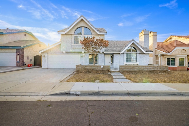 view of front of property with an attached garage, a tiled roof, concrete driveway, stucco siding, and a chimney