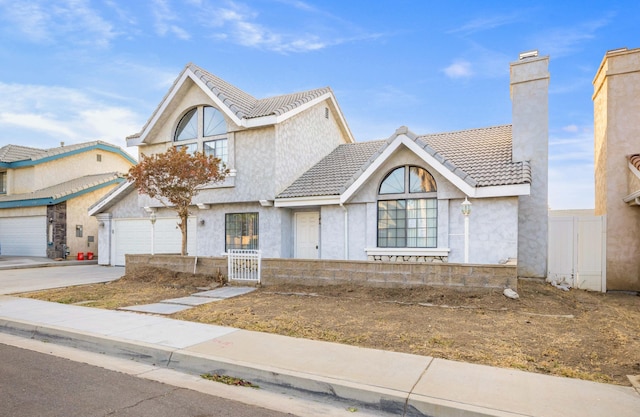 view of front of home with a garage, concrete driveway, a chimney, and a tile roof