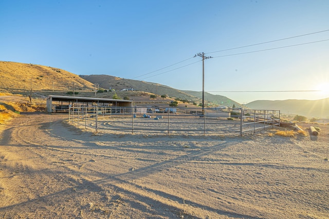 view of yard featuring a mountain view, a rural view, and an outbuilding