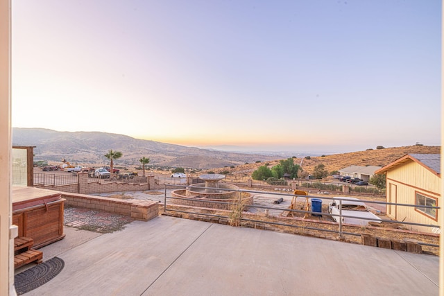 patio terrace at dusk featuring a mountain view