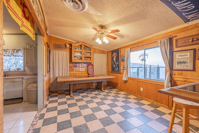 office area featuring vaulted ceiling, crown molding, ceiling fan, and wooden walls