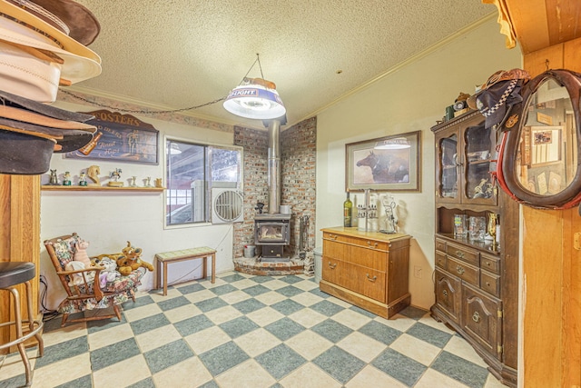 interior space featuring a wood stove, a textured ceiling, and ornamental molding