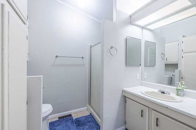 bathroom featuring tile patterned flooring, vanity, toilet, and a shower with door