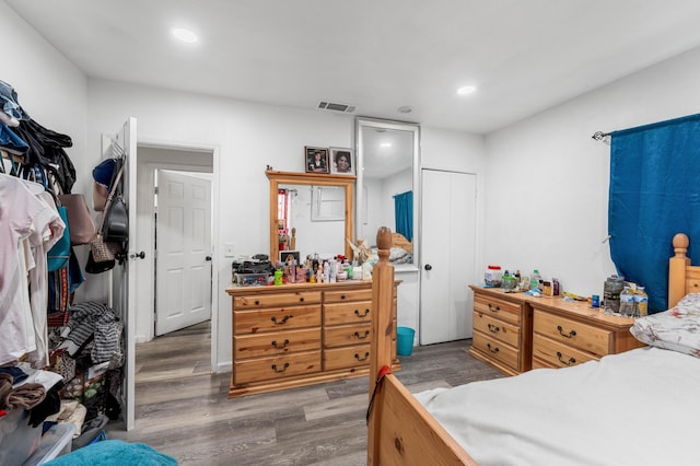 bedroom featuring a closet, wood finished floors, visible vents, and recessed lighting