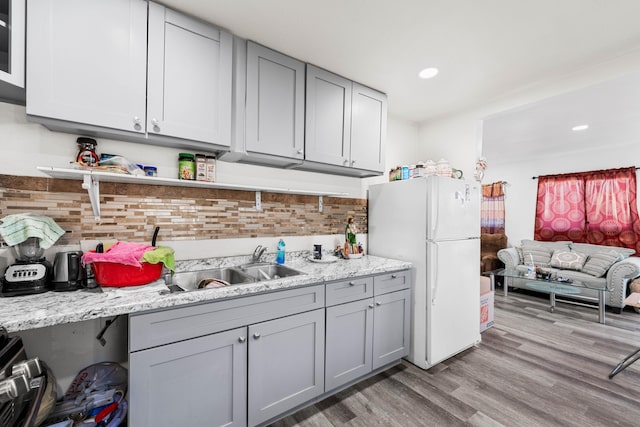 kitchen with light wood-type flooring, gray cabinets, and freestanding refrigerator