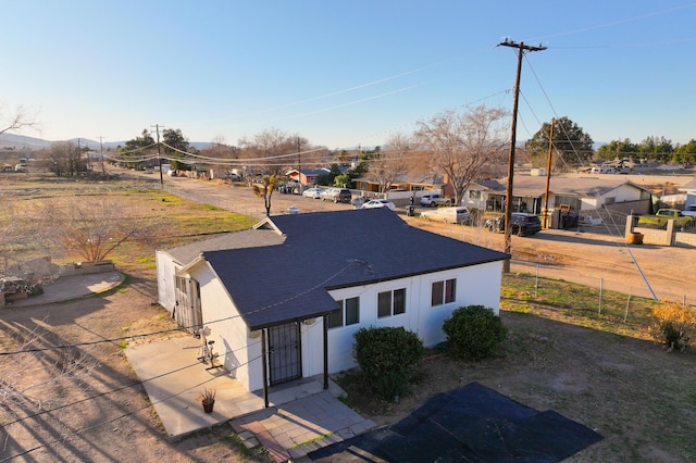 view of front of house featuring a residential view, fence, and stucco siding