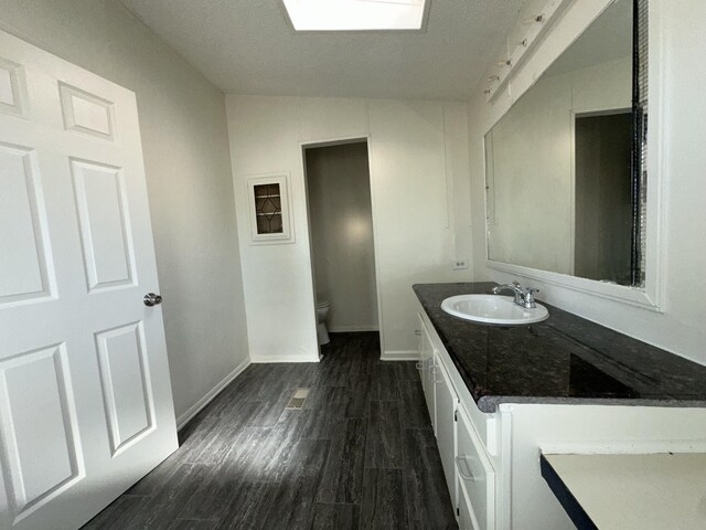 bathroom featuring vanity, wood-type flooring, and toilet