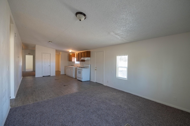 unfurnished living room with lofted ceiling, a textured ceiling, and dark colored carpet