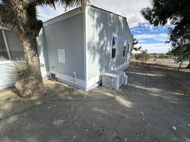 view of side of home with ac unit