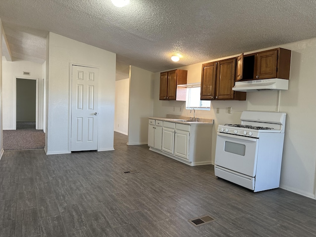 kitchen featuring dark hardwood / wood-style flooring, white gas range, and sink