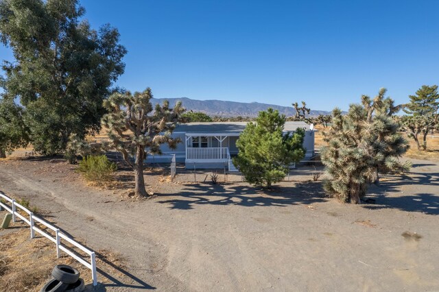 view of front of property with a mountain view, a rural view, and covered porch