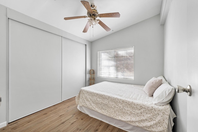 bedroom featuring ceiling fan, lofted ceiling, wood-type flooring, and a closet