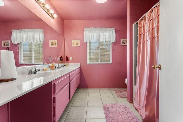 bathroom with tile patterned flooring, vanity, toilet, and plenty of natural light