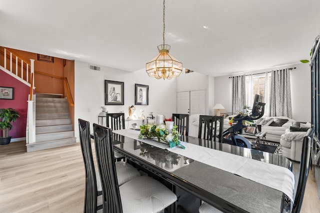 dining area featuring light hardwood / wood-style floors and a chandelier