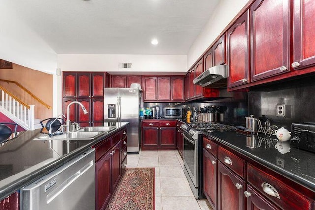 kitchen featuring backsplash, light tile patterned floors, sink, and appliances with stainless steel finishes