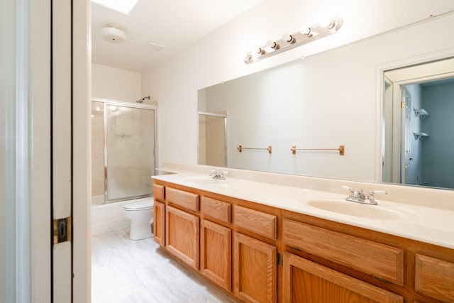 full bathroom with vanity, toilet, and shower / bath combination with glass door