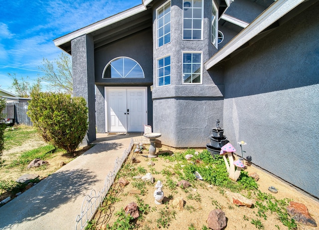 doorway to property featuring stucco siding