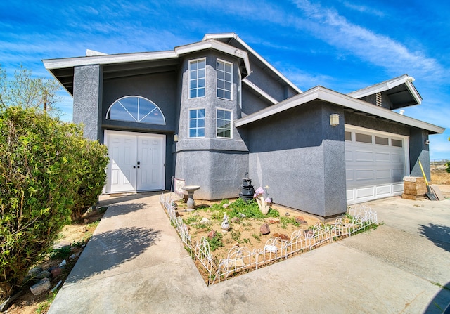 view of front of home featuring stucco siding, an attached garage, and concrete driveway