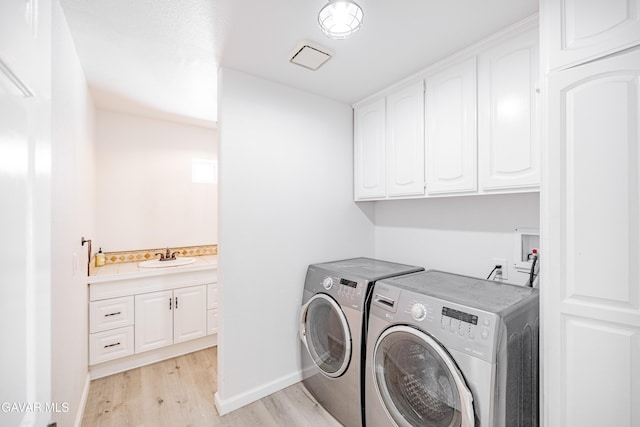 3807 Paula Ln, Lancaster, CA 93535 - washroom featuring cabinet space, washer and clothes dryer, and light wood-type flooring