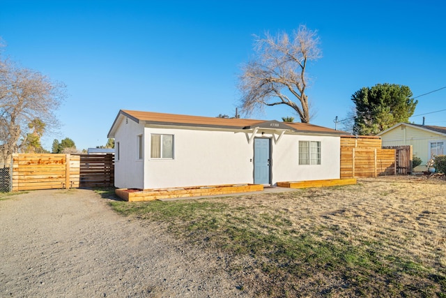 rear view of property with fence and stucco siding