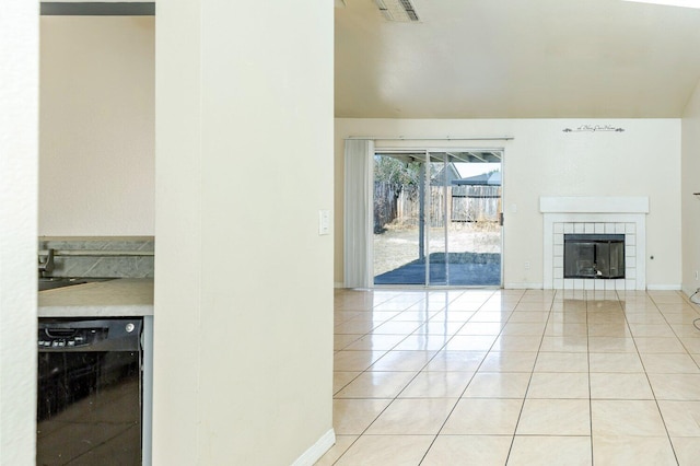 unfurnished living room featuring a tile fireplace and light tile patterned floors