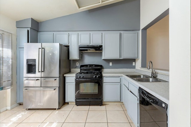 kitchen with black appliances, lofted ceiling, light tile patterned floors, and sink