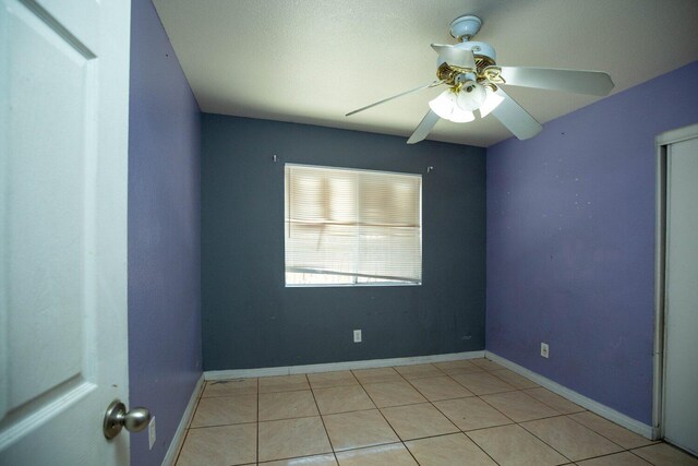 unfurnished room with ceiling fan and light tile patterned flooring