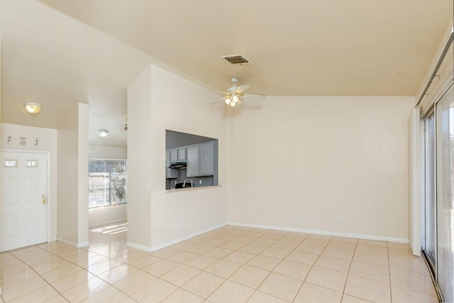 interior space featuring light tile patterned floors, vaulted ceiling, and ceiling fan