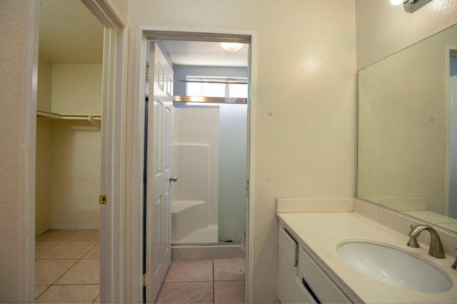 bathroom with tile patterned flooring, vanity, and an enclosed shower