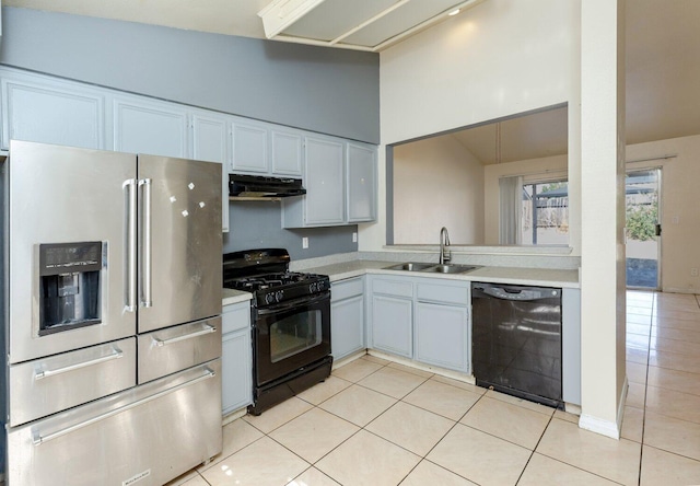 kitchen featuring sink, black appliances, light tile patterned floors, white cabinets, and lofted ceiling