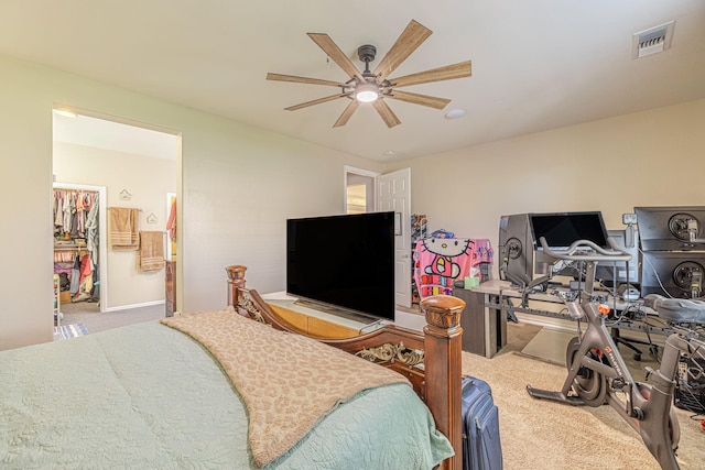 carpeted bedroom featuring a ceiling fan, an office area, and a spacious closet