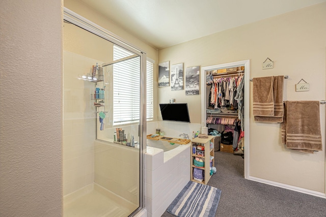 bathroom featuring a shower stall and a spacious closet