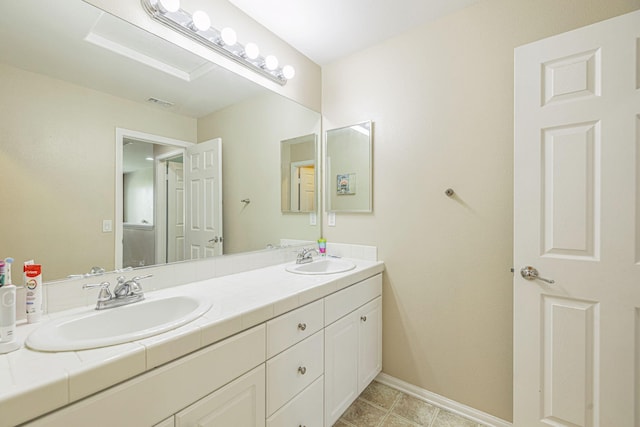 bathroom with double vanity and baseboards