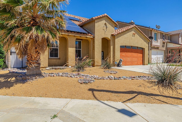 view of front facade featuring stucco siding, solar panels, a garage, concrete driveway, and a tiled roof