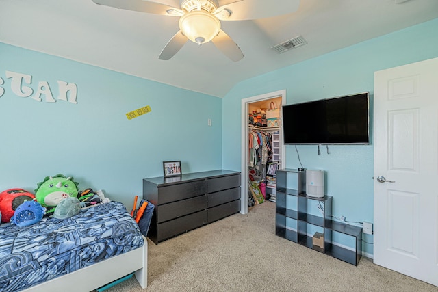 carpeted bedroom with lofted ceiling, ceiling fan, a walk in closet, and a closet