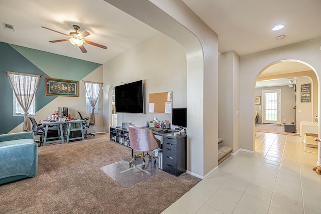 carpeted home office with arched walkways, a ceiling fan, baseboards, tile patterned flooring, and recessed lighting