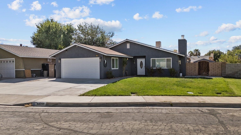 ranch-style home with a garage and a front lawn