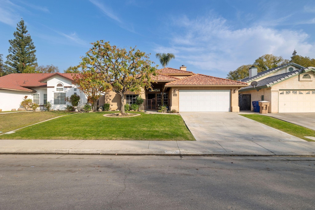 single story home featuring a front yard and a garage