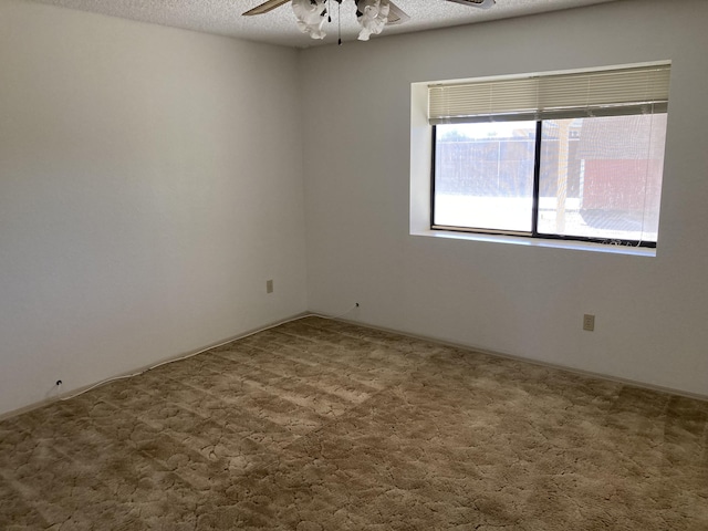 unfurnished room with carpet, ceiling fan, and a textured ceiling