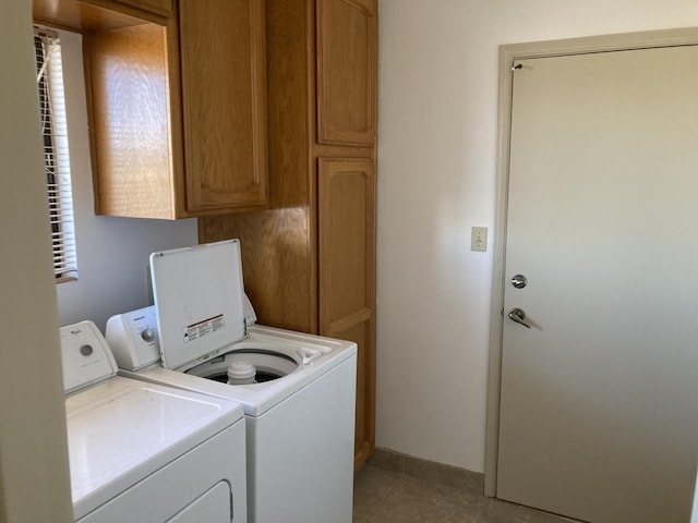 laundry room featuring washing machine and dryer and cabinets