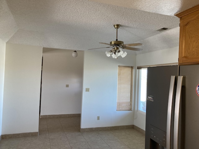 kitchen with ceiling fan, stainless steel fridge with ice dispenser, a textured ceiling, and vaulted ceiling