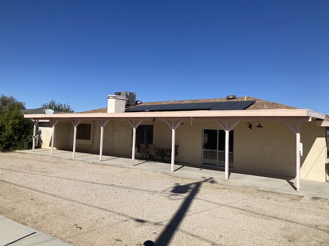 back of house featuring solar panels and a patio area