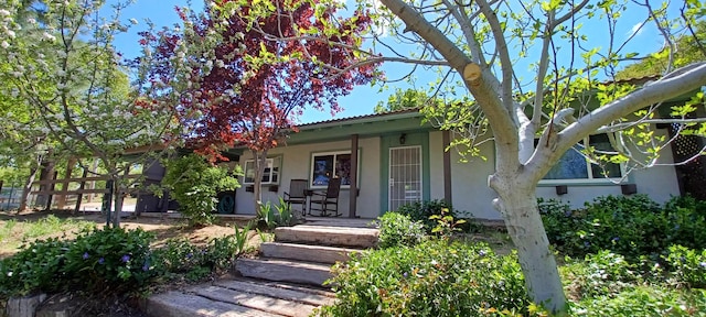property entrance featuring covered porch and stucco siding